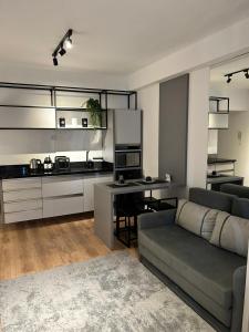 uma sala de estar com um sofá e uma cozinha em Studio LifeSpace Batel Curitiba em Curitiba