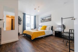 a bedroom with a large bed with yellow pillows at Contemporary 2 bedroom Apartment - Birmingham City Centre - Digbeth Bullring in Birmingham