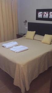 a bed with two towels on top of it at Apart Hotel La Recova in Termas de Río Hondo