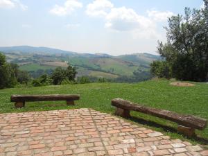 two wooden benches sitting on top of a hill at L'Isola Che Non C'era in Apiro