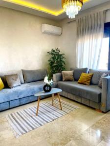 un soggiorno con divano blu e tavolo di Ultra Luxury 1BR in Gueliz a Marrakech