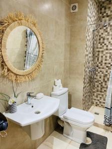 bagno con servizi igienici, lavandino e specchio di Ultra Luxury 1BR in Gueliz a Marrakech