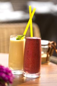 two glasses of different colored drinks on a table at Zuckmann Villa in Piešťany +33 photos