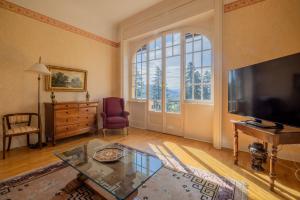 sala de estar con TV grande y mesa de cristal en Villa Volpe Como, en Lanzo d'Intelvi