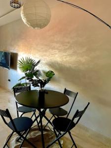 tavolo da pranzo con sedie e pianta in vaso di Ultra Luxury 1BR in Gueliz a Marrakech