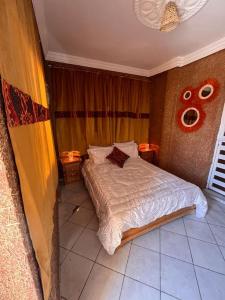 Hôtel Chez MARZOUQ في أزيلال: غرفة نوم بها سرير مع مصباحين
