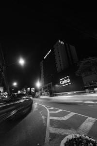 eine Stadtstraße in der Nacht mit Gebäuden und Straßenbeleuchtung in der Unterkunft Hotel Caiuá Blumenau in Blumenau