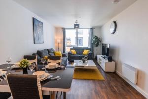 a living room with a couch and a dining room at Contemporary 2 bedroom Apartment - Birmingham City Centre - Digbeth Bullring in Birmingham
