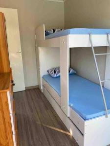 1 Schlafzimmer mit 2 Etagenbetten mit blauer Bettwäsche in der Unterkunft CHÁCARA C/ PISCINA, SALÃO DE FESTA E CHURRASQUEIRA in Campo Largo