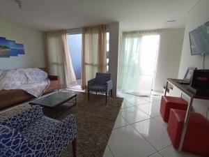 uma sala de estar com uma cama e uma mesa em Casa pertinho da praia com piscina, wifi; em Vila Velha