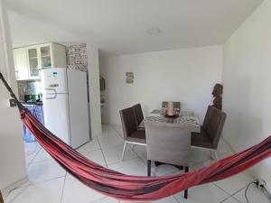 uma rede de descanso numa cozinha com uma mesa e um frigorífico em Casa pertinho da praia com piscina, wifi; em Vila Velha