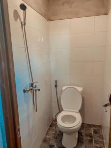 uma casa de banho com um WC e um chuveiro em Reddoorz Holistic Pod Hostel Kuta em Kuta