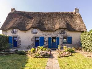 Cette ancienne maison en pierre est dotée d'un toit de chaume et de portes bleues. dans l'établissement Gîte Herbignac, 3 pièces, 6 personnes - FR-1-306-1108, à Herbignac