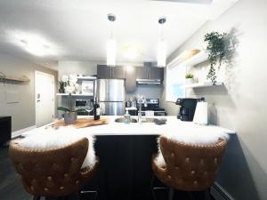 a kitchen with a counter and two bar stools at Boutique Bliss in the Heart of Wortley Village in London