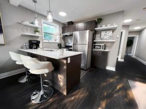 a kitchen with a counter and a sink and a refrigerator at Contemporary Comfort | Centrally Located Gem in London
