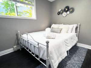 a bedroom with a bed with white sheets and a window at *NEW* Elegant Urban 2BR Retreat in London