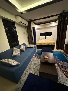 a room with two beds and a blue couch at Villa Silia in Sharm El Sheikh