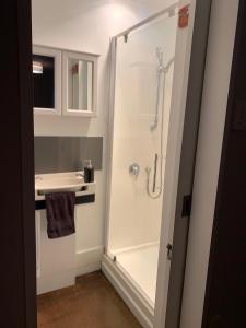 a white bathroom with a shower and a sink at American Rustic Barn in Hamilton