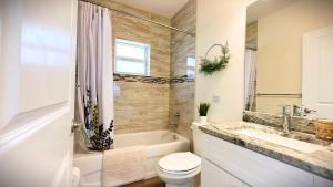 a bathroom with a tub and a toilet and a sink at Tropical Florida Getaway - Stuart House in Stuart +46 photos