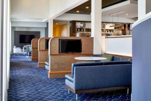 メンフィスにあるCourtyard by Marriott Memphis Airportのソファとテレビ付きの待合室