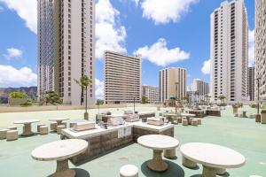 a patio with tables and chairs and tall buildings at Huge Patio WasherDryer 1 Bedroom Banyan Free Parking 5 min to Beach in Honolulu