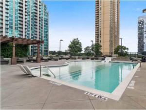 a large swimming pool in a city with tall buildings at Blue Luxe- Highrise Living, 2 bd,2 ba, All season Pool - S06 in Atlanta