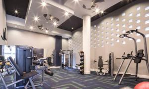 a gym with treadmills and machines in a room at Blue Luxe-Highrise, Balcony, Pool, City View! in Atlanta