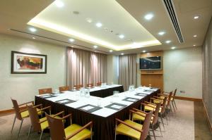 Montreal Barsha Hotel في دبي: قاعة المؤتمرات مع طاولة وكراسي طويلة