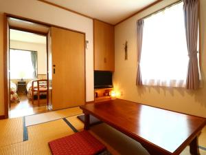 Pension Avenue في ياماناكاكو: غرفة معيشة مع طاولة خشبية ونافذة