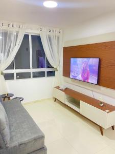 uma sala de estar com uma televisão de ecrã plano na parede em Apto Garagem Wifi Condomínio Piscina Ar-condicionado 2 Quartos em Petrolina