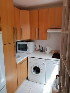uma cozinha com uma máquina de lavar roupa e um micro-ondas em CASA MARINE DU SOLEIL 60 em Patrimonio