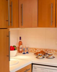 um balcão de cozinha com um lavatório e uma garrafa de álcool em CASA MARINE DU SOLEIL 60 em Patrimonio