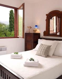 um quarto com uma grande cama branca com duas plantas em CASA MARINE DU SOLEIL 60 em Patrimonio