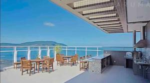 a patio with a table and chairs and the ocean at Flat vista mar em Santos in Santos