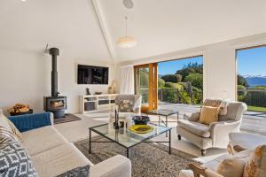 a living room with white furniture and a fireplace at Hāwea Lakehouse - Lake Hāwea Holiday Home in Lake Hawea