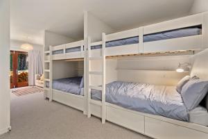 a bedroom with white bunk beds in a house at Hāwea Lakehouse - Lake Hāwea Holiday Home in Lake Hawea