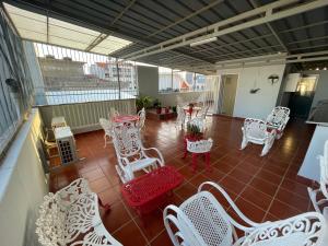 d'un balcon avec des chaises blanches, des tables et des chaises. dans l'établissement Isa House - Private Rooms in a Shared Duplex, à Praia