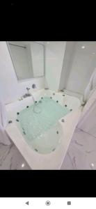 a bathroom with a bath tub filled with water at סטודיו עם גקוזי ענק מול כינרת in Tiberias