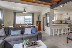 a living room with a couch and a kitchen at OceanCatcher - newly remodeled 3 bedroom retreat with ocean view in the heart of Mission Beach, sleeps 10 in San Diego