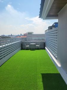 a balcony with green grass on the side of a building at Hotel razaB in Pohang