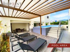 een patio met tafels en stoelen en een zwembad bij 2 Bedroom Condo @ Midpoint Residences w/ City View in Mandaue-stad