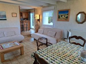 uma sala de estar com um sofá e uma mesa em holiday home, Landéda em Landéda
