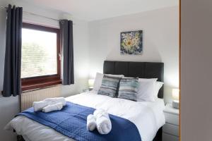 a bedroom with a bed with towels on it at Executive Apartment By Inverkeithing Train Station in Fife