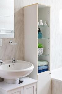 a white bathroom with a sink and a mirror at Executive Apartment By Inverkeithing Train Station in Fife