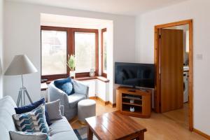 sala de estar con sofá y TV en Executive Apartment By Inverkeithing Train Station en Fife