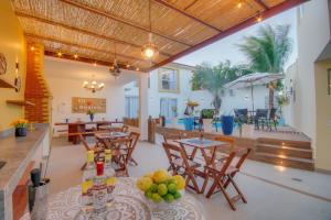 a dining room with tables and chairs and a patio at Pousada Nanina de Geribá in Búzios