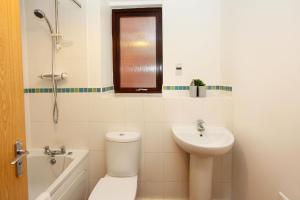 y baño con aseo, lavabo y ducha. en Autumn Heights Apartments en Telford