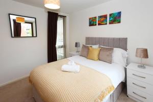 1 dormitorio con 1 cama con manta amarilla en Autumn Heights Apartments en Telford