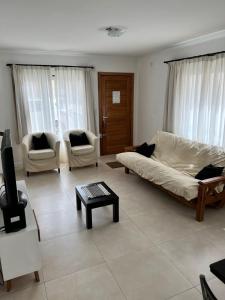 ein Wohnzimmer mit einem Sofa und 2 Stühlen in der Unterkunft Departamento Monseñor in Tandil