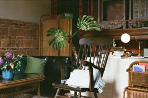 Zimmer mit einem Stuhl und einem Tisch mit einer Pflanze in der Unterkunft 序室 Narrative in Jinhu